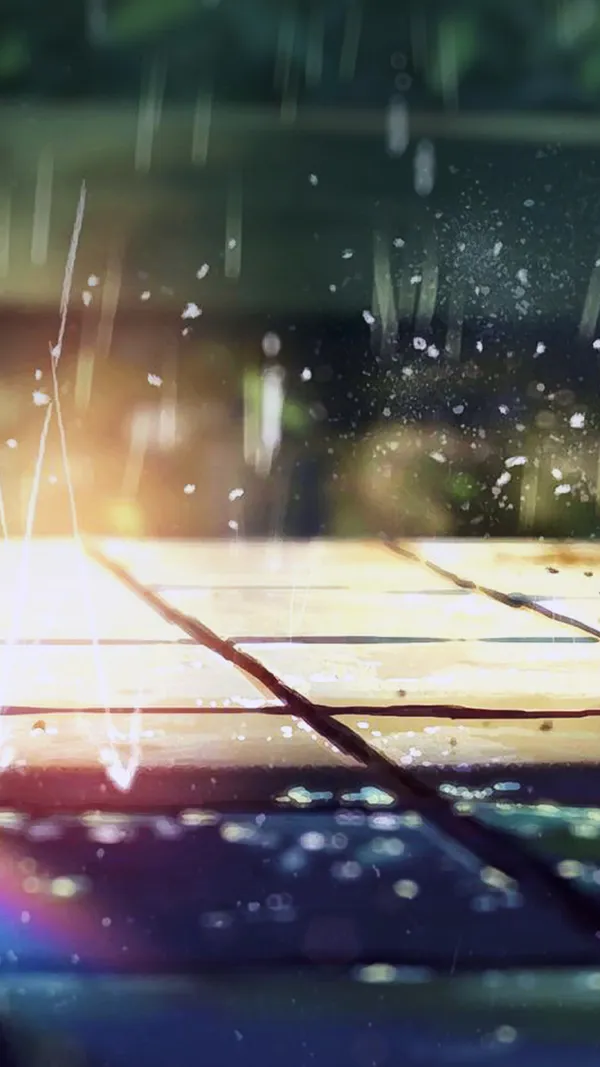 Raindrops falling on a wooden table with a blurred background