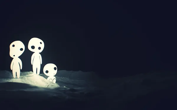 Three glowing white creatures on a dark, snowy landscape