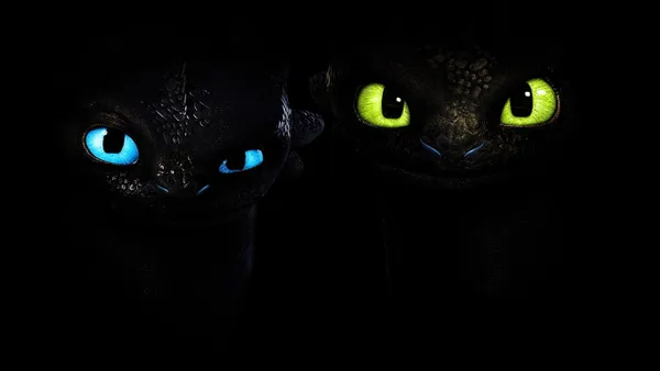 Two dragons with blue and green eyes in the dark